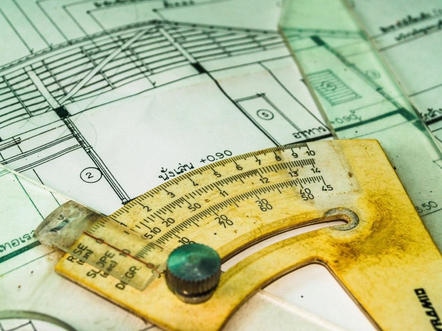 Planta baixa e desenho técnico sobre a mesa de trabalho